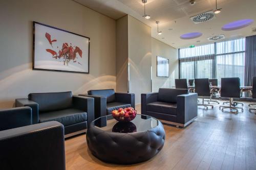 a waiting room with couches and a bowl of fruit at Radisson Blu Hotel, Hamburg in Hamburg