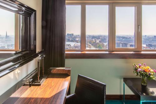 a room with a table and a view of the city at Radisson Blu Hotel, Hamburg in Hamburg