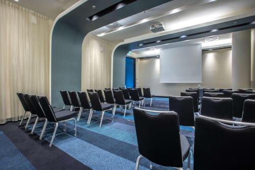 a conference room with chairs and a white screen at Radisson Blu Hotel, Hamburg in Hamburg