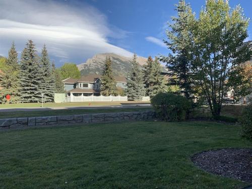 a large yard with a house in the background at NEW! Cozy Rocky Mountain Chalet managed by Little Sister Getaways in Canmore