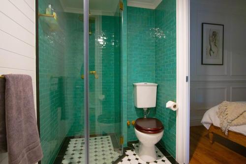 a bathroom with a toilet and a glass shower at Ultima- Unique elegance in Port Douglas in Port Douglas