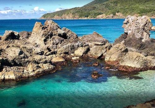 a large group of rocks in the water at 4 Bedroom modern house opposite Wallis Lake in Forster