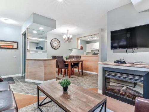 a living room with a table and a fireplace at NEW! Cozy Rocky Mountain Chalet managed by Little Sister Getaways in Canmore