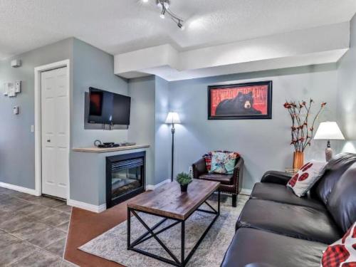 a living room with a couch and a fireplace at NEW! Cozy Rocky Mountain Chalet managed by Little Sister Getaways in Canmore