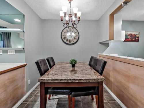 a dining room with a table with chairs and a chandelier at NEW! Cozy Rocky Mountain Chalet managed by Little Sister Getaways in Canmore