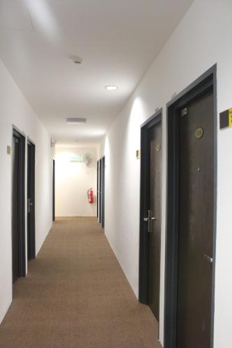 a corridor of a hallway with black doors at Grand Inn Hotel - Macalister Road in George Town
