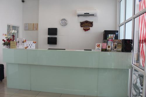 a counter in a room with a clock on the wall at Grand Inn Hotel - Macalister Road in George Town