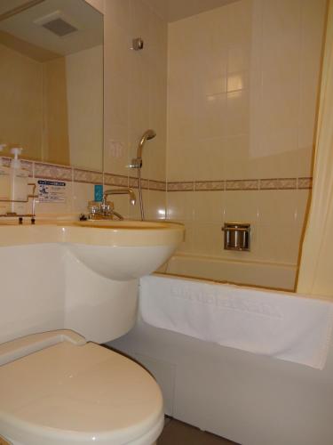a bathroom with a toilet and a sink and a tub at Smile Hotel Nara in Nara