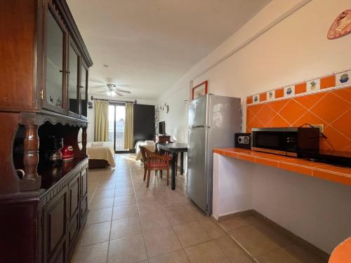 una cucina con frigorifero in acciaio inox e tavolo di Suites Fenicia a Playa del Carmen