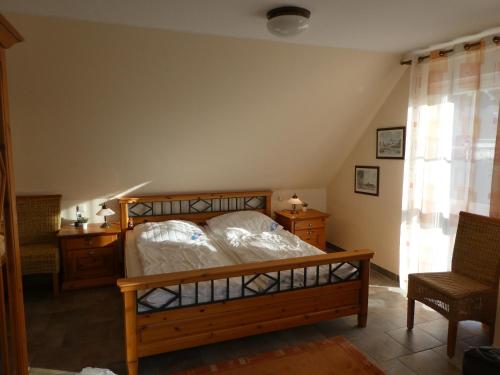 a bedroom with a bed and a chair and a window at "Utkiek" im "Roden Hus" in Timmendorf