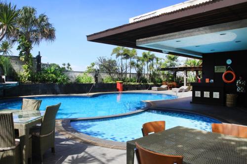 een zwembad met een tafel en stoelen en een patio bij Daily Home Apartment in Bandung