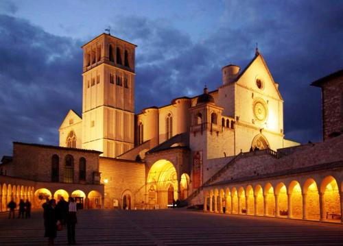 a large building with a clock tower at night at Hotel Cristallo di La Rosetta Srl in Assisi