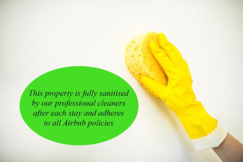 墨尔本Mega Style Apartments St Kilda的戴着黄手套,手持热狗的人