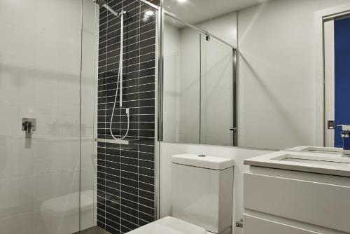a bathroom with a shower and a toilet and a sink at Mega Style Apartments St Kilda in Melbourne