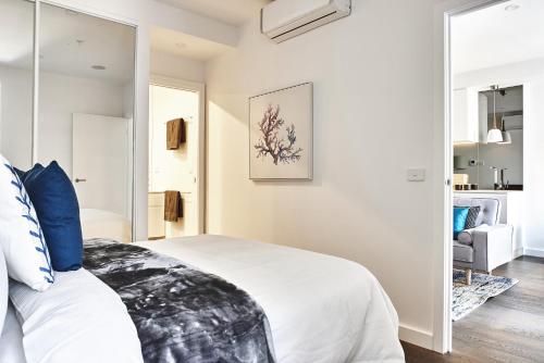 a bedroom with a bed and a mirror at Mega Style Apartments St Kilda in Melbourne