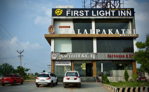 un edificio con due auto parcheggiate di fronte di The First Light Inn a Kanchipuram