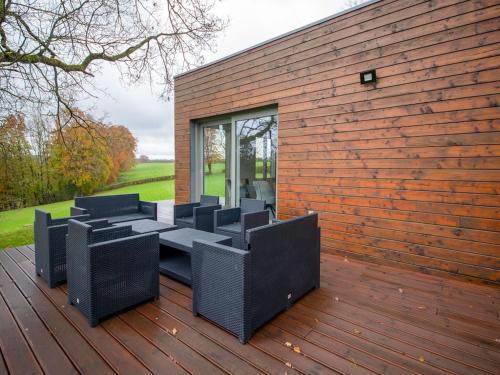 een groep stoelen op een houten terras bij Holiday home in Waimes on the shores of Lake Roberville in Waimes