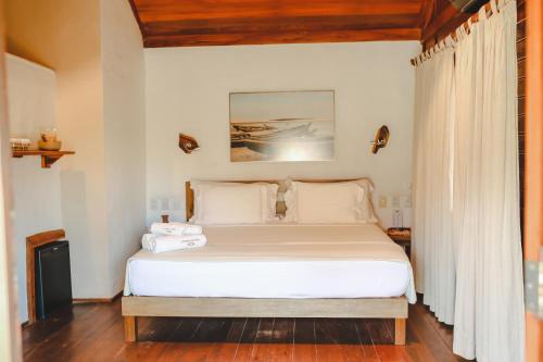 a bedroom with a large bed with white sheets at Hurricane Jeri in Jericoacoara