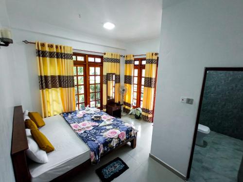 a bedroom with a bed in a room with windows at Daffodils Inn in Adams Peak