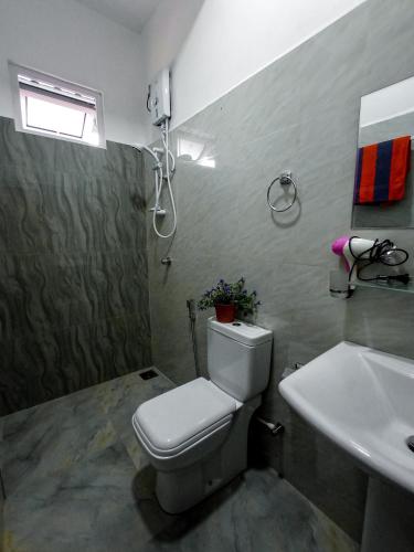 a bathroom with a toilet and a sink at Daffodils Inn in Adams Peak