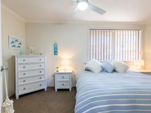 a bedroom with a bed and a dresser and a window at Fingal Court 2 2 Lentara St in Fingal Bay