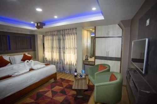 PashupatināthにあるHotel Marinhaのベッドと椅子のあるホテルの部屋