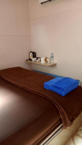 a bed with a brown blanket on top of it at Canaan in Kanchanaburi