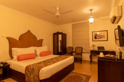 a hotel room with a bed and a desk at Amritara Suryauday Haveli in Varanasi