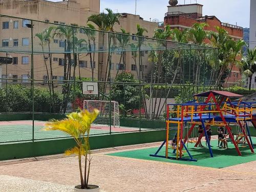 a playground with colorful play equipment on a tennis court at Apartamento na Praia da Enseada - Guarujá in Guarujá