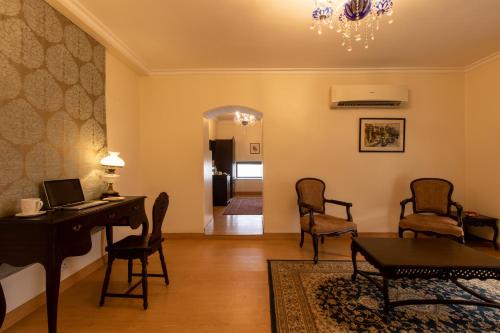 a living room with a desk and chairs and a table at Amritara Suryauday Haveli in Varanasi