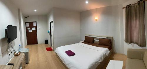 a bedroom with a bed and a couch and a television at Alongkorn hotel by SB in Samut Songkhram