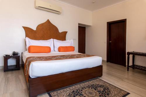 a bedroom with a large bed with orange pillows at Amritara Suryauday Haveli in Varanasi