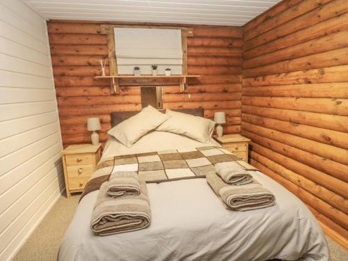 a bedroom with a bed in a log cabin at Ingram in Morpeth