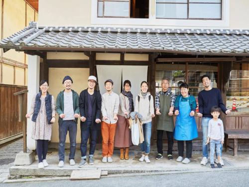 a group of people standing in front of a building at Hostel & Tatami Bar Uchikobare -内子晴れ- in Uchiko