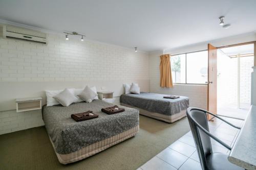 a hotel room with two beds and a couch at Capella Hotel Motel in Capella
