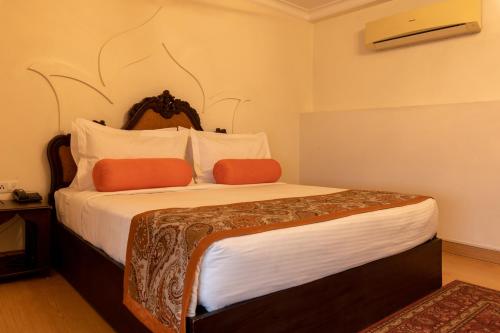 a bedroom with a large bed with orange pillows at Amritara Suryauday Haveli in Varanasi