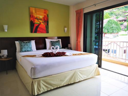 duże łóżko w pokoju z dużym oknem w obiekcie Seven Seas Hotel w Patong Beach