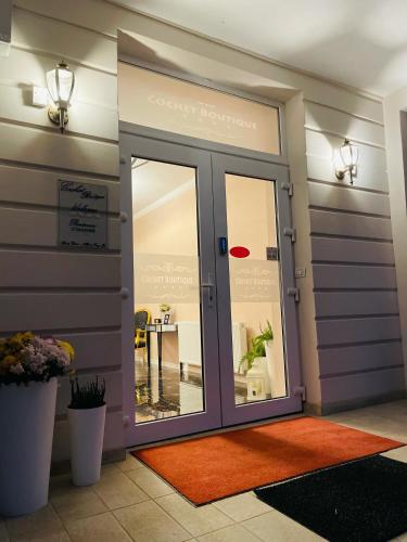 a room with a glass door with a table at COCHET BOUTIQUE in Târgu Jiu