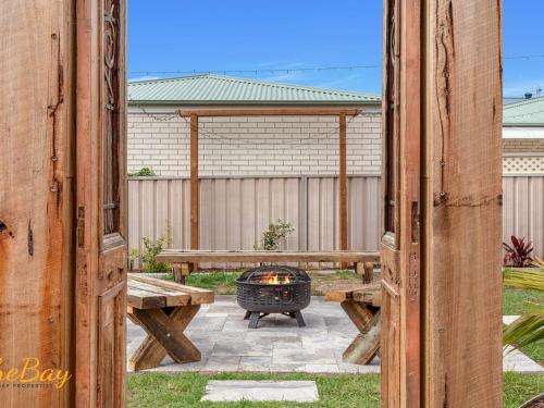 a patio with a grill and a picnic table at Waves on Whitesands in Fingal Bay