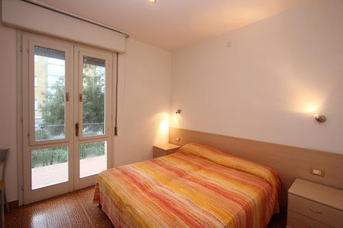 1 dormitorio con cama y ventana grande en Beautiful villa just few steps from the beach en Bibione