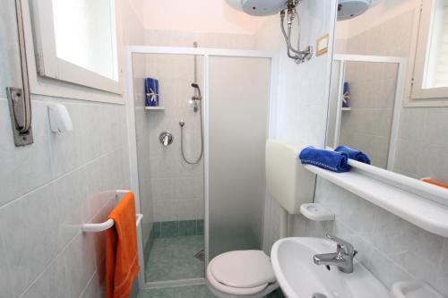 uma casa de banho com um WC, um lavatório e um chuveiro em Beautiful villa just few steps from the beach em Bibione