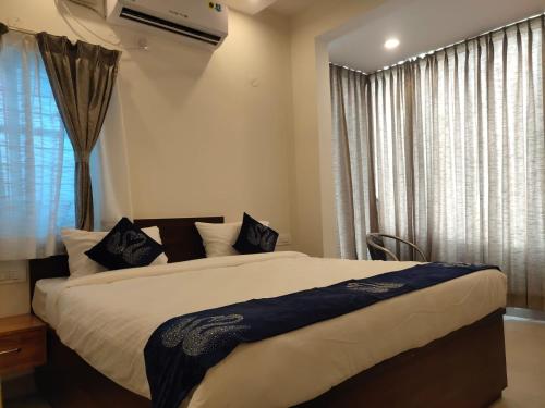 a bedroom with a large bed and a window at AMULYA FINE DINE RESIDENCY in Bangalore