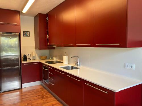 a kitchen with red cabinets and a white counter top at Apartament Pla del Roc in La Molina