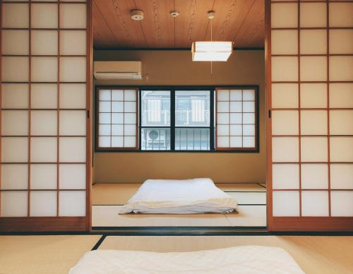 a room with a bed and two windows at Kyoto Nijo Guest House HoshiIke villa in Kyoto