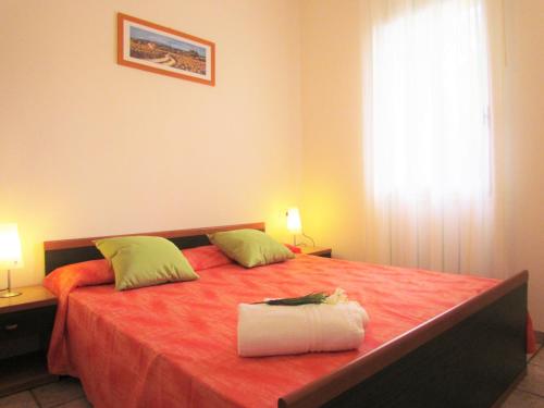 una camera da letto con un grande letto con una coperta rossa di The perfect family retreat - Beahost a Bibione