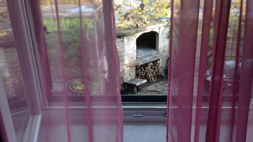 a view of a stone fireplace through a window at Holiday home Marija in Vrlika