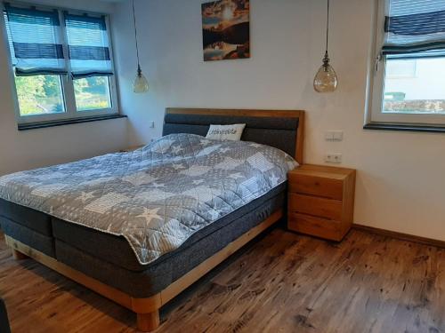 ein Schlafzimmer mit einem Bett und einem Holzboden in der Unterkunft Main Lieblingsplatz in Langenprozelten