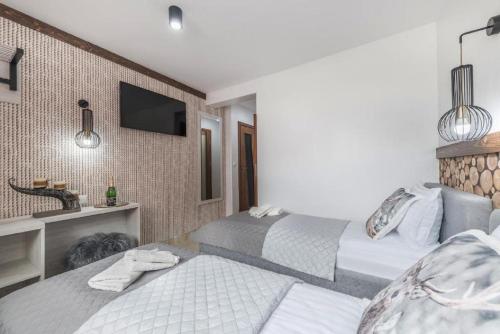 a hotel room with two beds and a sink at Biały Jeleń z basenem i jacuzzi in Białka Tatrzanska