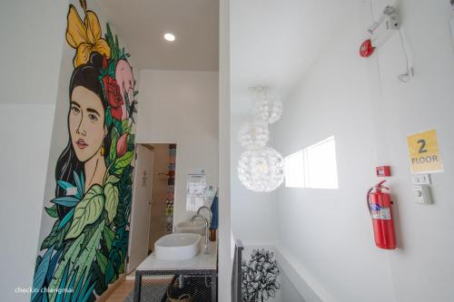 a bathroom with a painting of a woman on the wall at Hostel Lullaby Non-Smoking in Chiang Mai