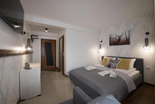 a bedroom with a bed with a painting on the wall at Biały Jeleń z basenem i jacuzzi in Białka Tatrzanska